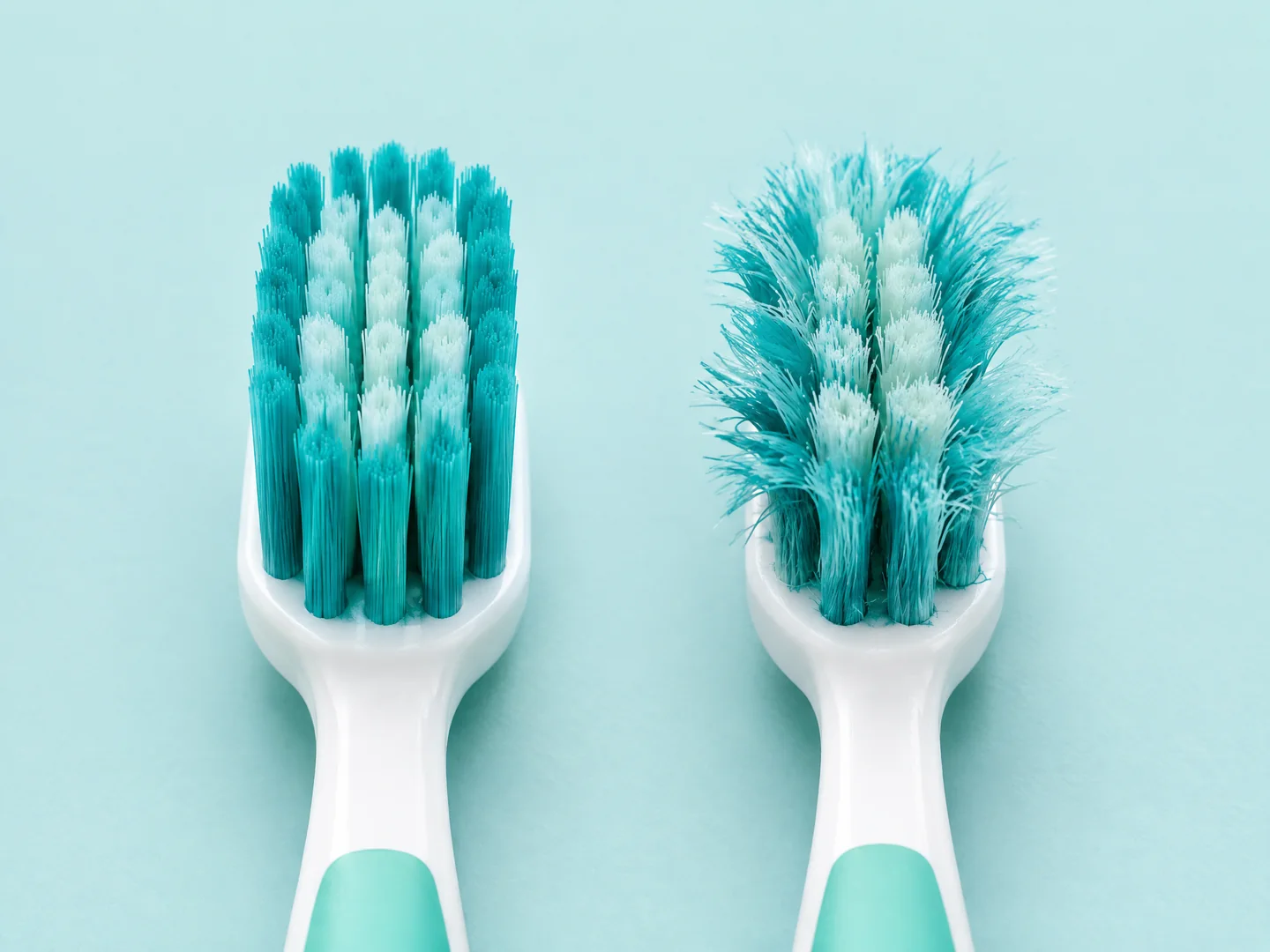 Side-by-side comparison of straight new toothbrush bristles and frayed worn bristles